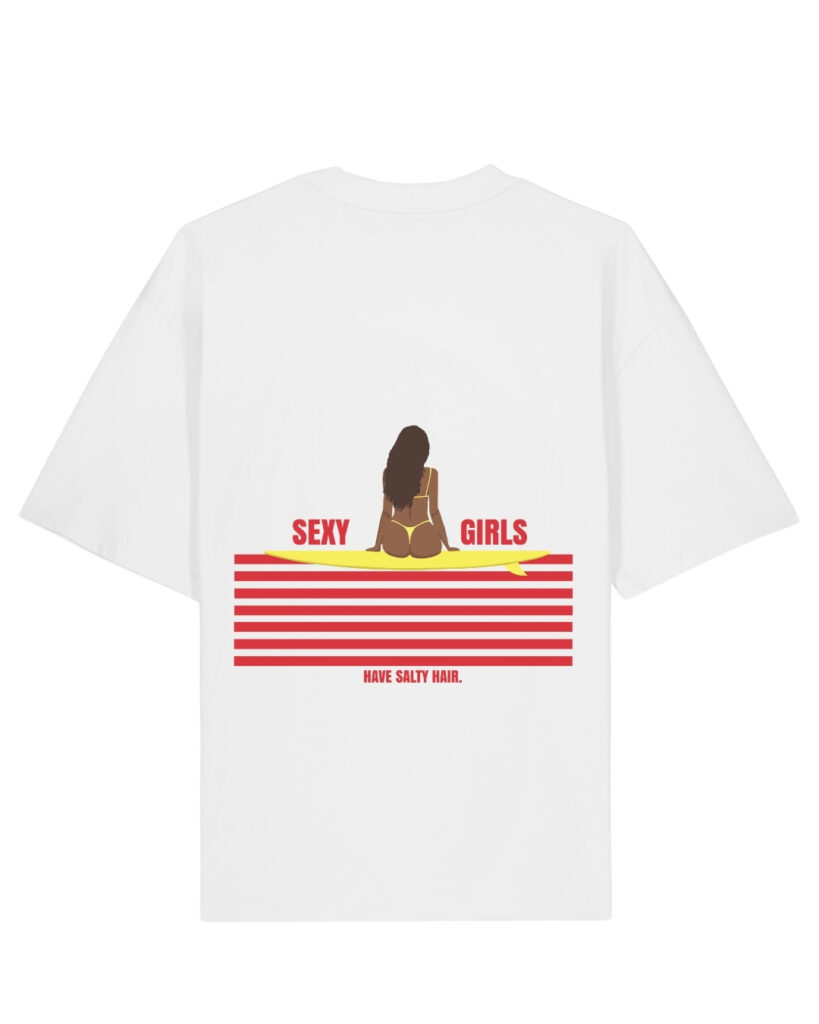 T-shirt oversize blanc avec une illustration représentant une femme brune assise de dos sur une planche de surf jaune. Sous la planche, plusieurs lignes horizontales rouges rappellent le coucher de soleil sur l'océan. Les mots « Sexy Girls » entourent la silhouette et la phrase « Have Salty Hair » est écrite en dessous. Le design est inspiré de l'univers du surf et de l'été.